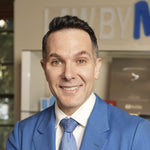 Smiling man in a blue suit and tie, looking directly at the camera.