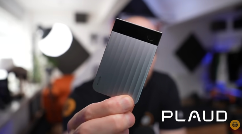 Silver Plaud Note Pro AI voice recorder held in a hand, showing its ribbed texture and small display screen.